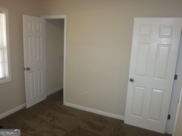 unfurnished bedroom with dark colored carpet