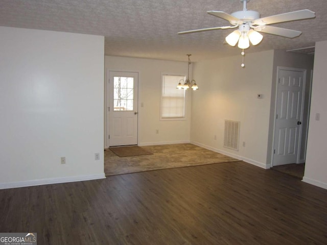 interior space with a textured ceiling, ceiling fan with notable chandelier, and dark hardwood / wood-style flooring