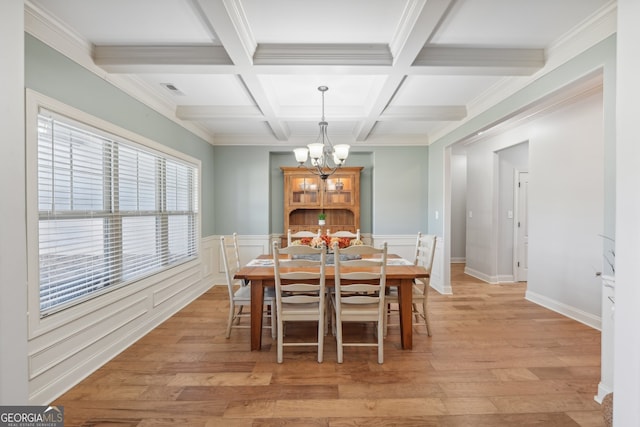 dining space with ornamental molding, beamed ceiling, coffered ceiling, and light wood-type flooring