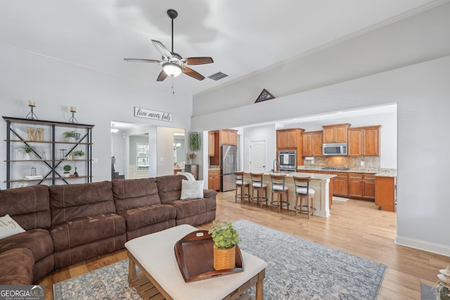 living room with ceiling fan and light wood-type flooring