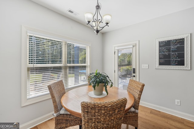 dining room with an inviting chandelier and hardwood / wood-style flooring