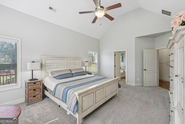 carpeted bedroom with ensuite bathroom, high vaulted ceiling, and ceiling fan