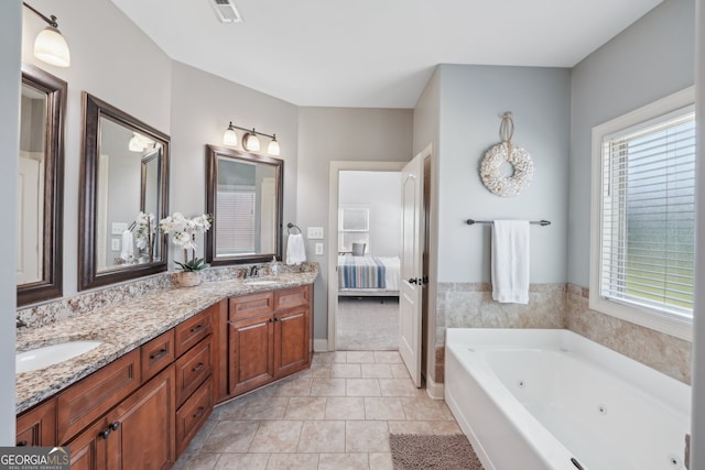 bathroom with tile patterned floors, a washtub, and vanity