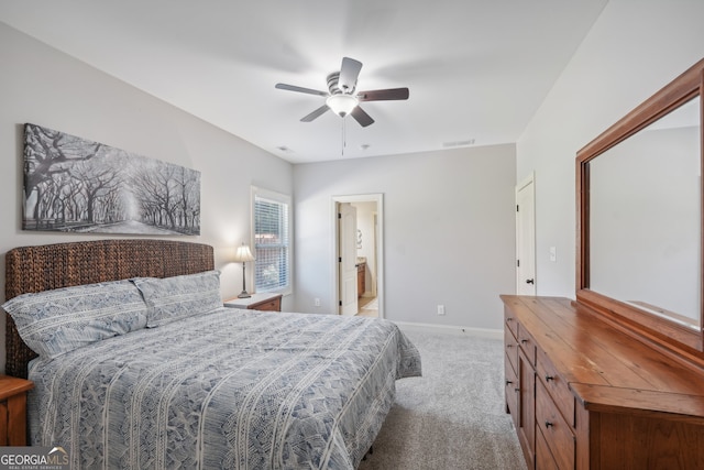 bedroom featuring ceiling fan, ensuite bathroom, and light carpet