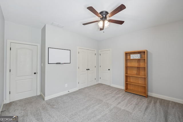 unfurnished bedroom with ceiling fan and light colored carpet