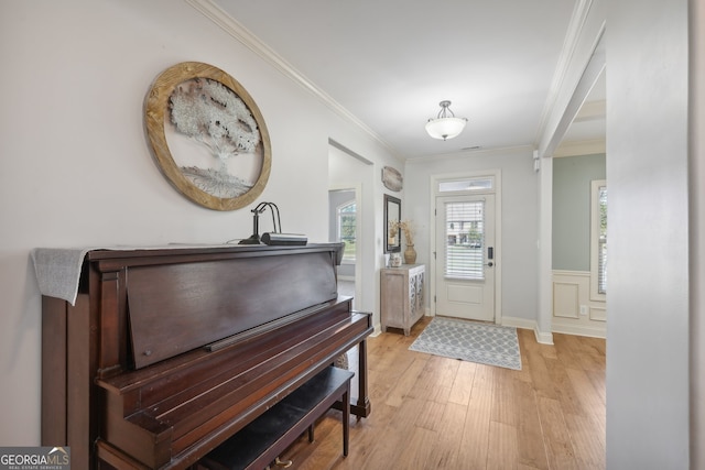 entryway featuring ornamental molding and light hardwood / wood-style flooring