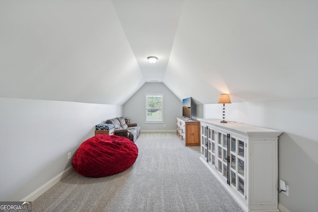 living area with light colored carpet and vaulted ceiling