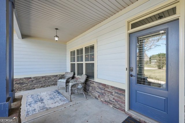 view of exterior entry featuring covered porch