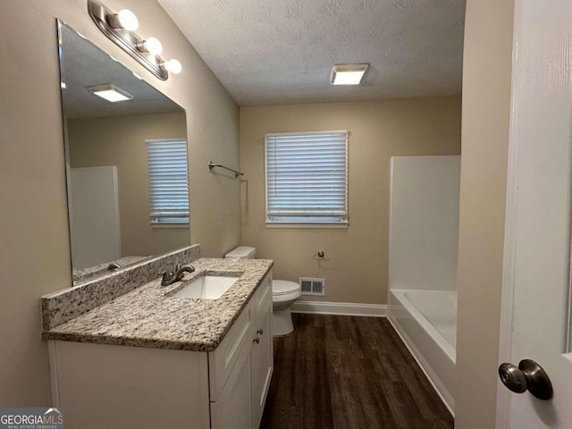 full bathroom featuring toilet, shower with separate bathtub, hardwood / wood-style flooring, vanity, and a textured ceiling