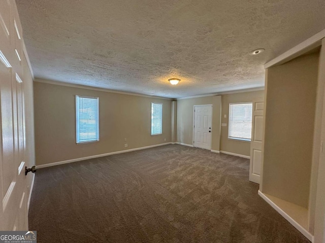 empty room with dark colored carpet and a textured ceiling