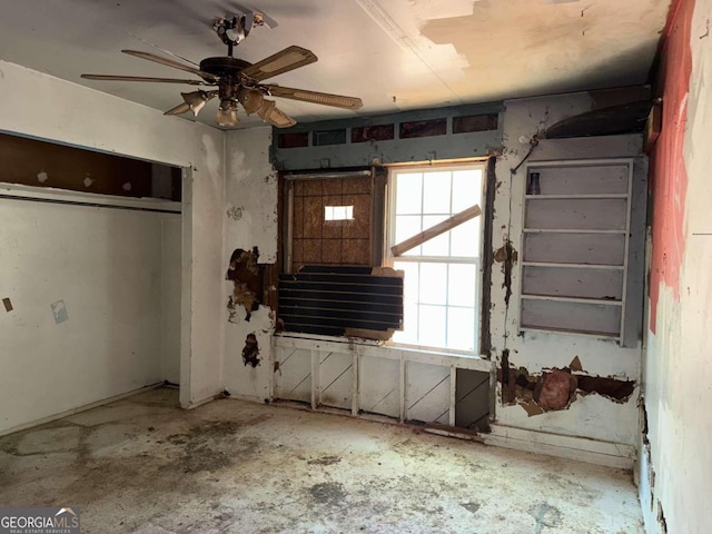 interior space featuring ceiling fan and concrete floors