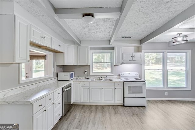 kitchen featuring white appliances, beamed ceiling, light wood-type flooring, and white cabinetry