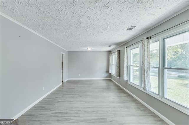 unfurnished room with a textured ceiling, crown molding, and light hardwood / wood-style flooring