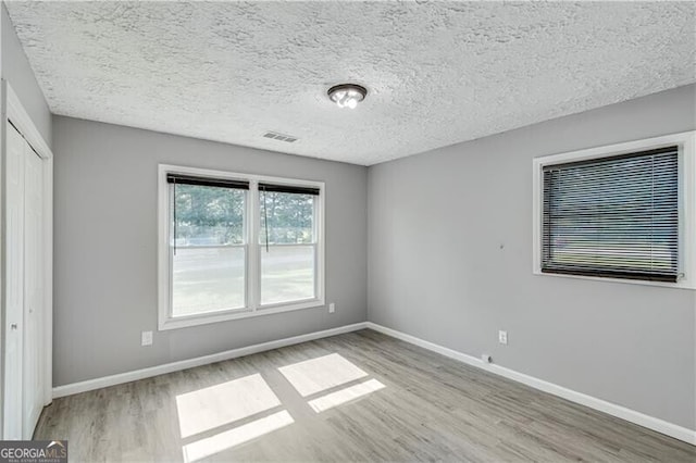 interior space with light wood-type flooring and a textured ceiling