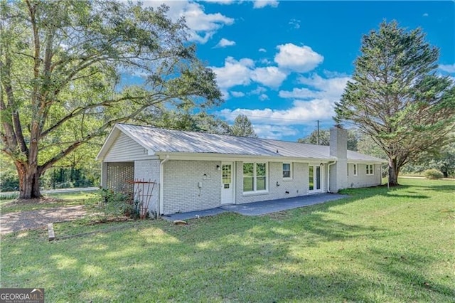 rear view of property featuring a yard and a patio