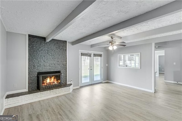 unfurnished living room with a textured ceiling and light hardwood / wood-style floors