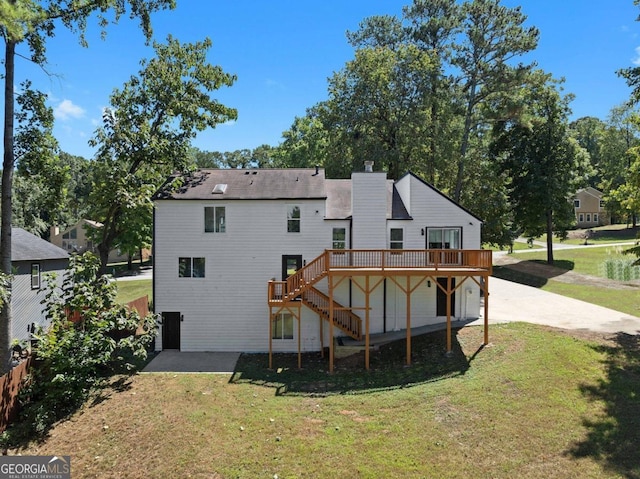 rear view of property with a deck and a lawn