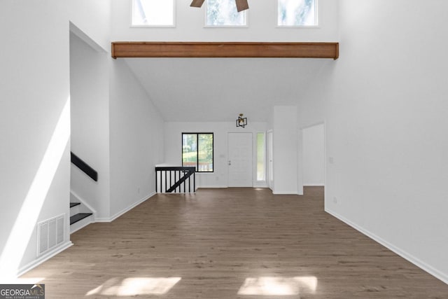 unfurnished living room with high vaulted ceiling, hardwood / wood-style flooring, and ceiling fan