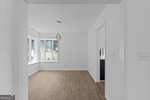 unfurnished room featuring hardwood / wood-style flooring and a textured ceiling