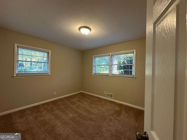 carpeted spare room with a textured ceiling