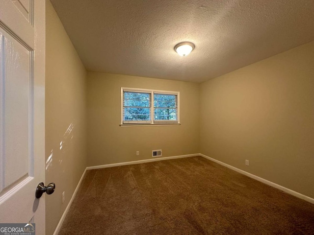 unfurnished room featuring a textured ceiling and carpet flooring