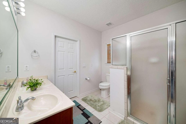 bathroom featuring tile patterned floors, vanity, a textured ceiling, toilet, and a shower with shower door