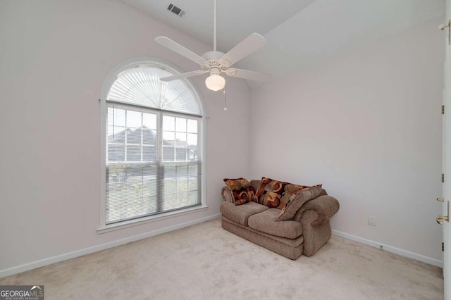 living area featuring ceiling fan, a healthy amount of sunlight, light carpet, and vaulted ceiling