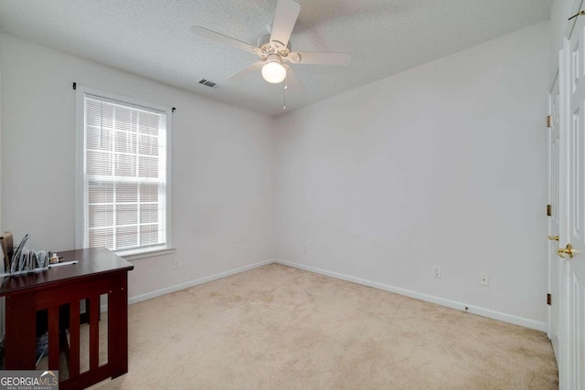 empty room featuring light carpet, a textured ceiling, plenty of natural light, and ceiling fan