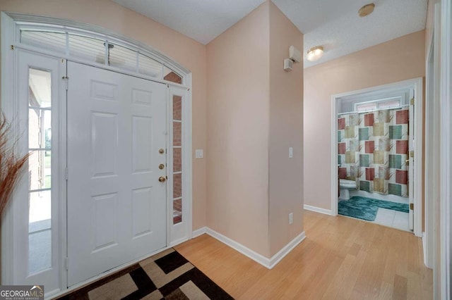 entrance foyer featuring a textured ceiling and light wood-type flooring