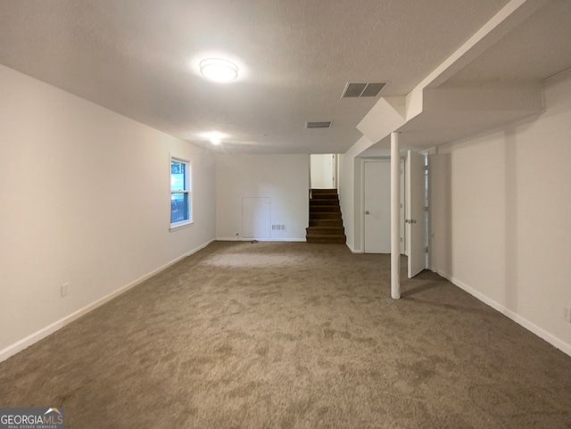 basement featuring carpet flooring and a textured ceiling