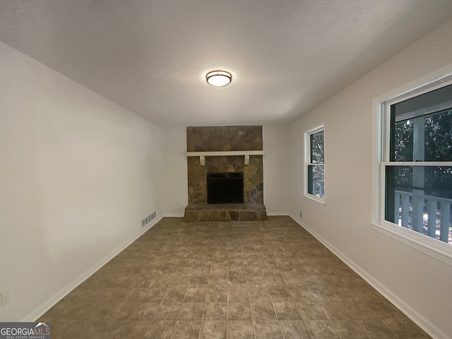 unfurnished living room featuring a fireplace and a healthy amount of sunlight