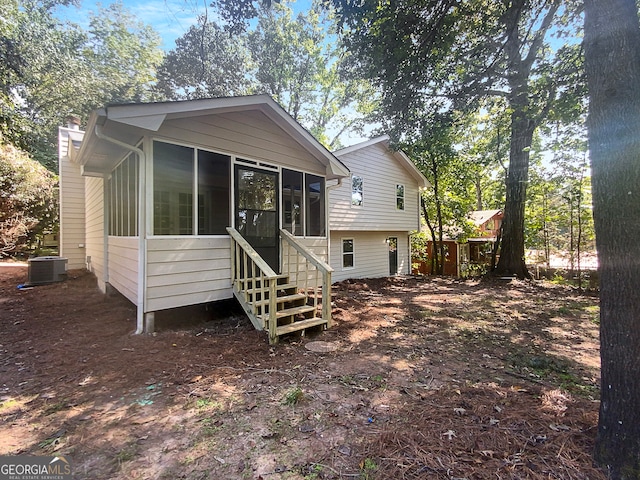 back of property featuring a sunroom and central AC unit