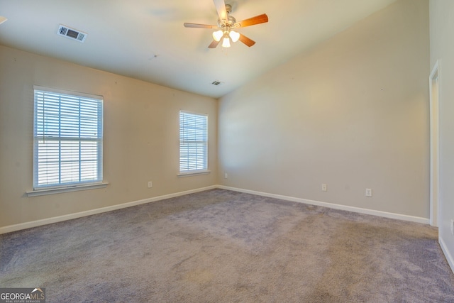 carpeted empty room with ceiling fan, lofted ceiling, and a healthy amount of sunlight