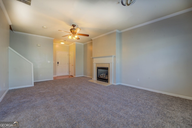 unfurnished living room with ceiling fan, ornamental molding, carpet, and a tile fireplace