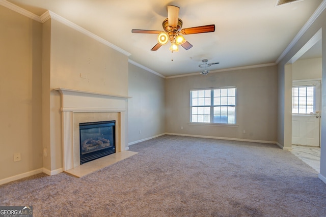 unfurnished living room with a healthy amount of sunlight, crown molding, a high end fireplace, and light colored carpet