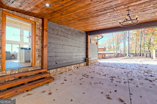 interior space featuring wooden ceiling and wooden walls