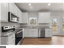 kitchen featuring stove, dark wood-type flooring, and white cabinetry