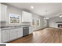 kitchen with dark wood-type flooring, decorative light fixtures, and white cabinets