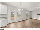 unfurnished living room with hardwood / wood-style floors and a chandelier