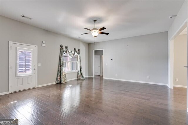 unfurnished room with dark wood-type flooring, ceiling fan, and plenty of natural light