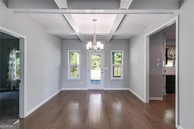 interior space featuring beam ceiling, coffered ceiling, dark hardwood / wood-style flooring, and a chandelier