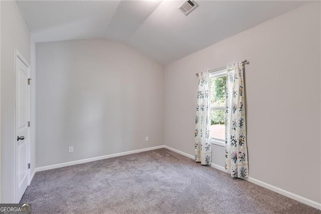 carpeted spare room featuring lofted ceiling