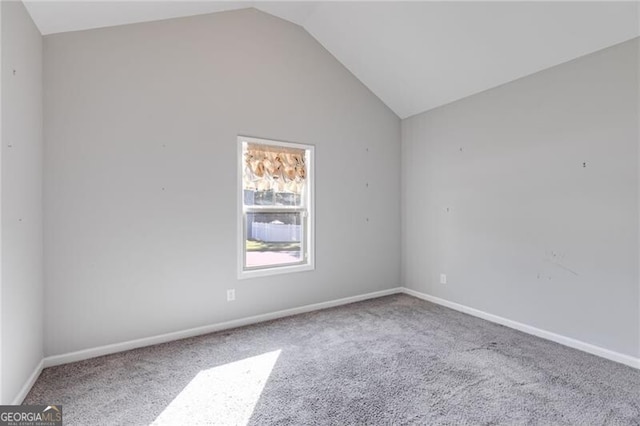 carpeted empty room featuring vaulted ceiling