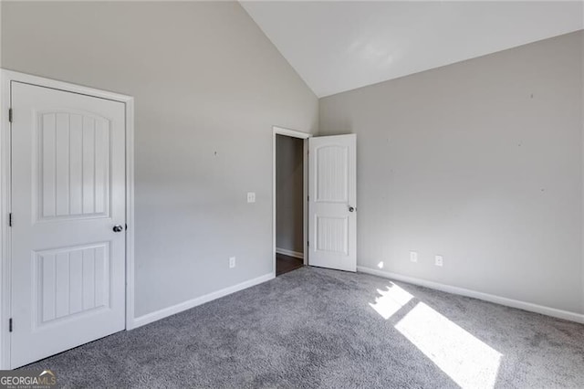 unfurnished bedroom with dark colored carpet and high vaulted ceiling