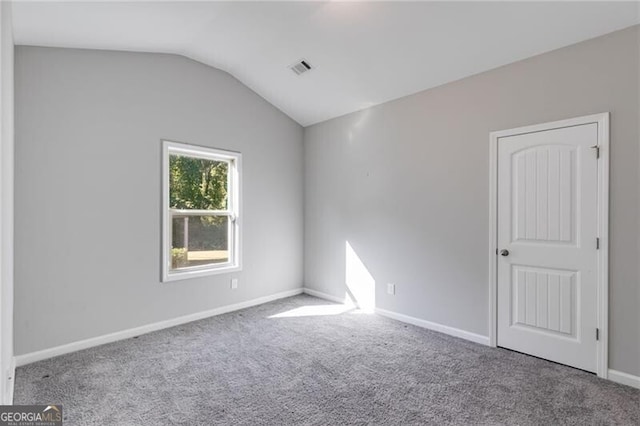 empty room with carpet and vaulted ceiling