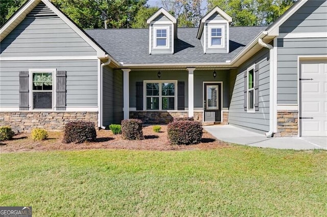 view of front facade with a front yard, covered porch, and a garage