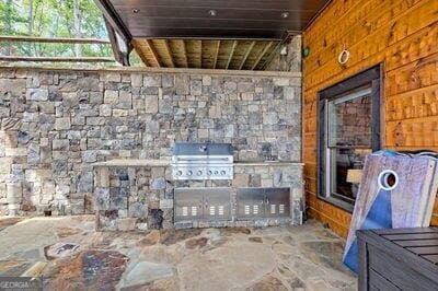 exterior space with an outdoor kitchen and grilling area