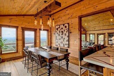 dining room with wood ceiling, lofted ceiling with beams, hardwood / wood-style flooring, and a healthy amount of sunlight