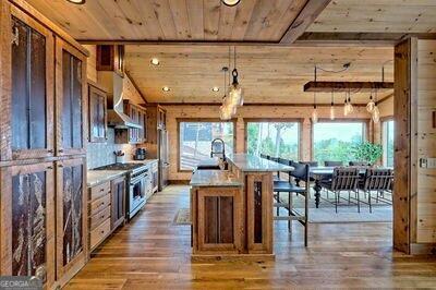 kitchen featuring extractor fan, a center island with sink, dark hardwood / wood-style flooring, and a wealth of natural light