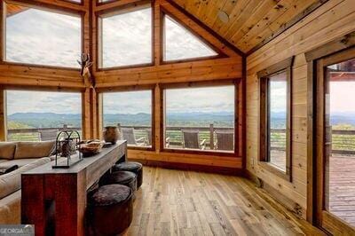 sunroom featuring a mountain view, vaulted ceiling, and wooden ceiling